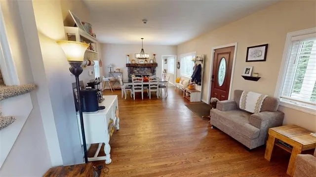 a view of a dining room and livingroom with furniture wooden floor a chandelier