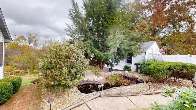 a view of a house with a big yard and large trees