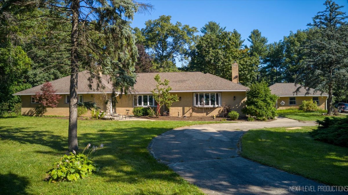 49W794 Lenschow Road Sycamore, IL 60178 - Photo 1 of 40 a view of a big house with a big yard and potted plants and large trees
