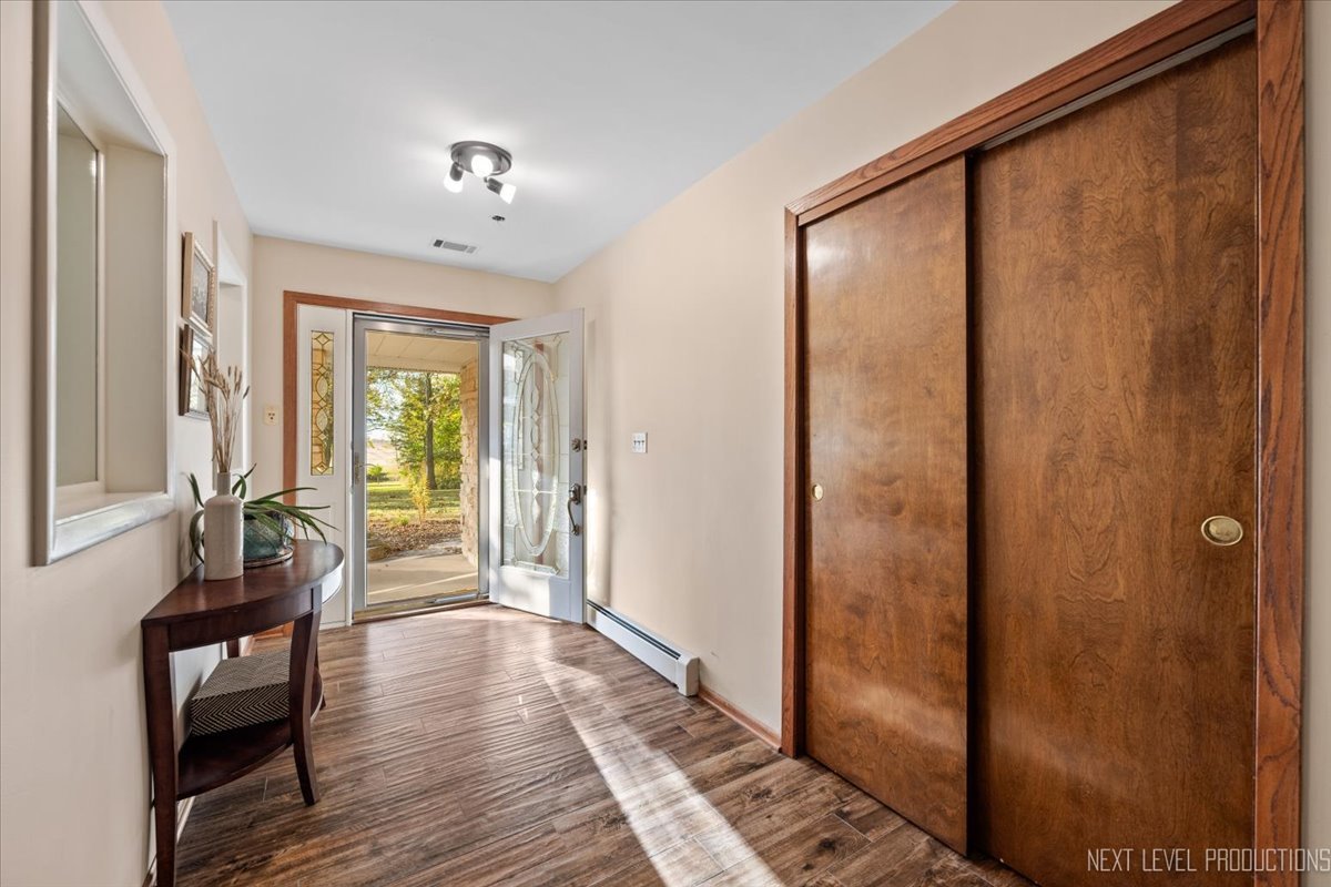 49W794 Lenschow Road Sycamore, IL 60178 - Photo 4 of 40 a view of a hallway with wooden floor and furniture