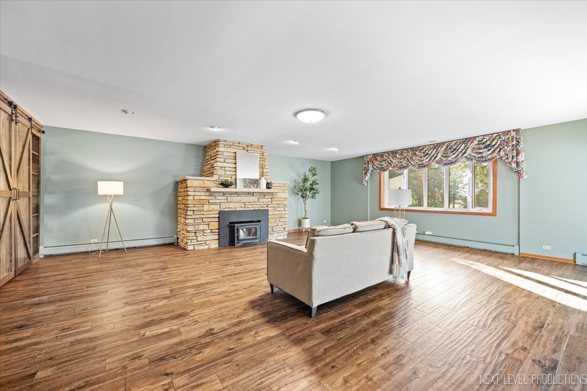 49W794 Lenschow Road Sycamore, IL 60178 - Photo 8 of 40 a living room with fireplace furniture and a wooden floor