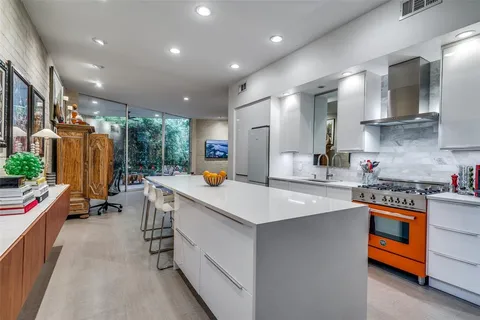 a kitchen that has a lot of cabinets a sink and wooden floor