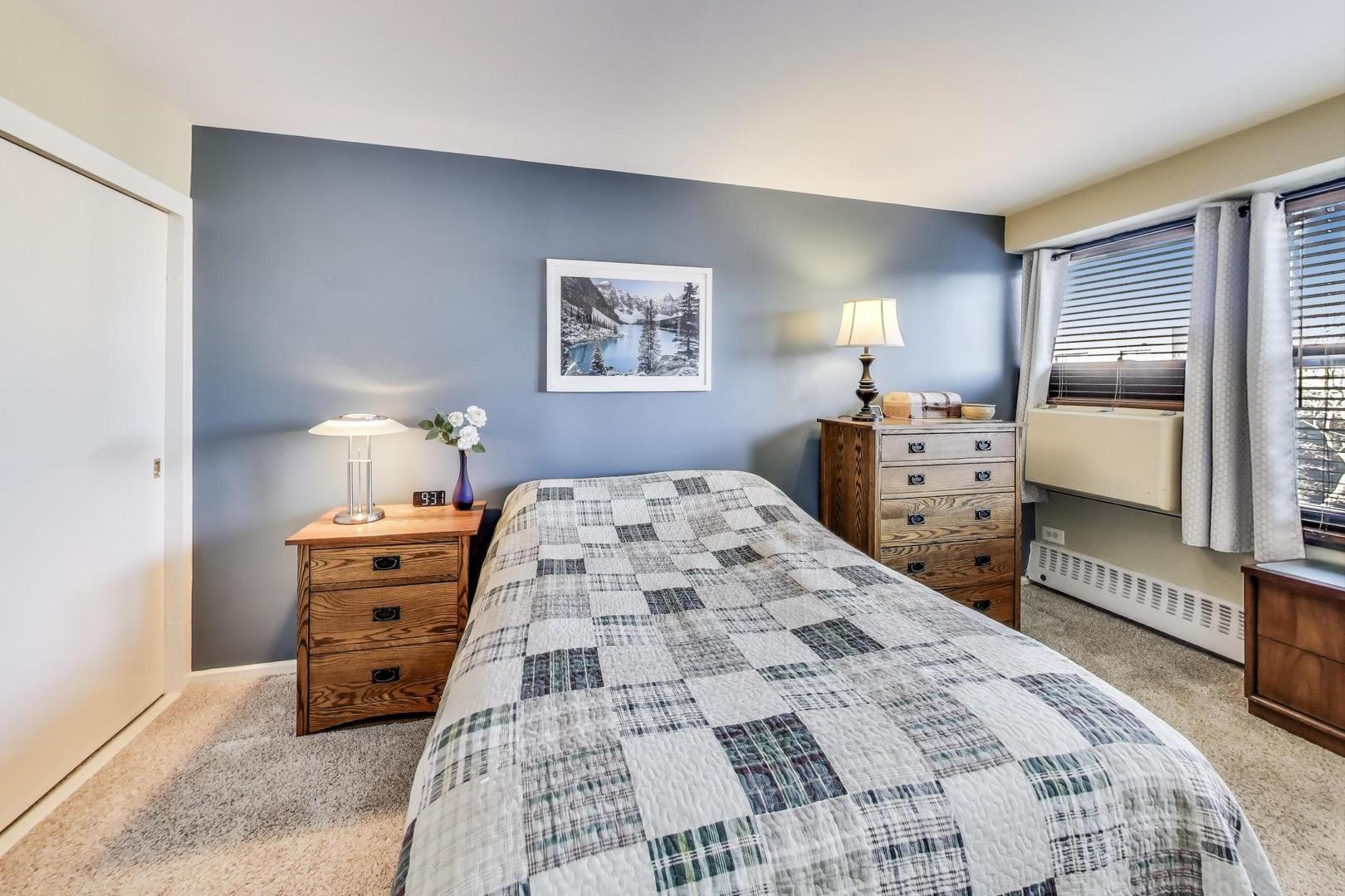 6030 North Sheridan Road, Unit 411 Chicago, IL 60660 - Photo 13 of 20 a bedroom with a bed and dresser with mirror