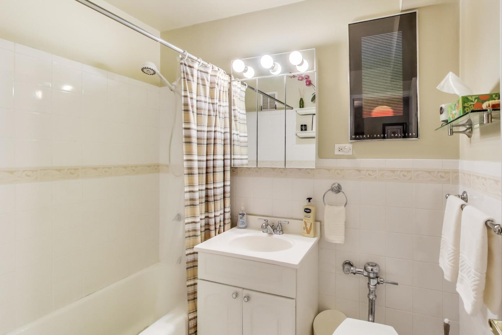6030 North Sheridan Road, Unit 411 Chicago, IL 60660 - Photo 15 of 20 a bathroom with a sink and a mirror