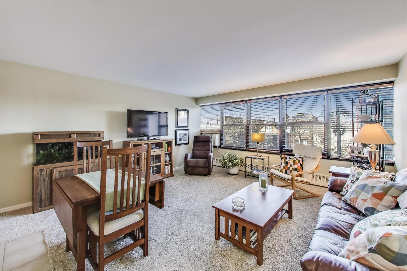 6030 North Sheridan Road, Unit 411 Chicago, IL 60660 - Photo 6 of 20 a living room with furniture a lamp and a large window