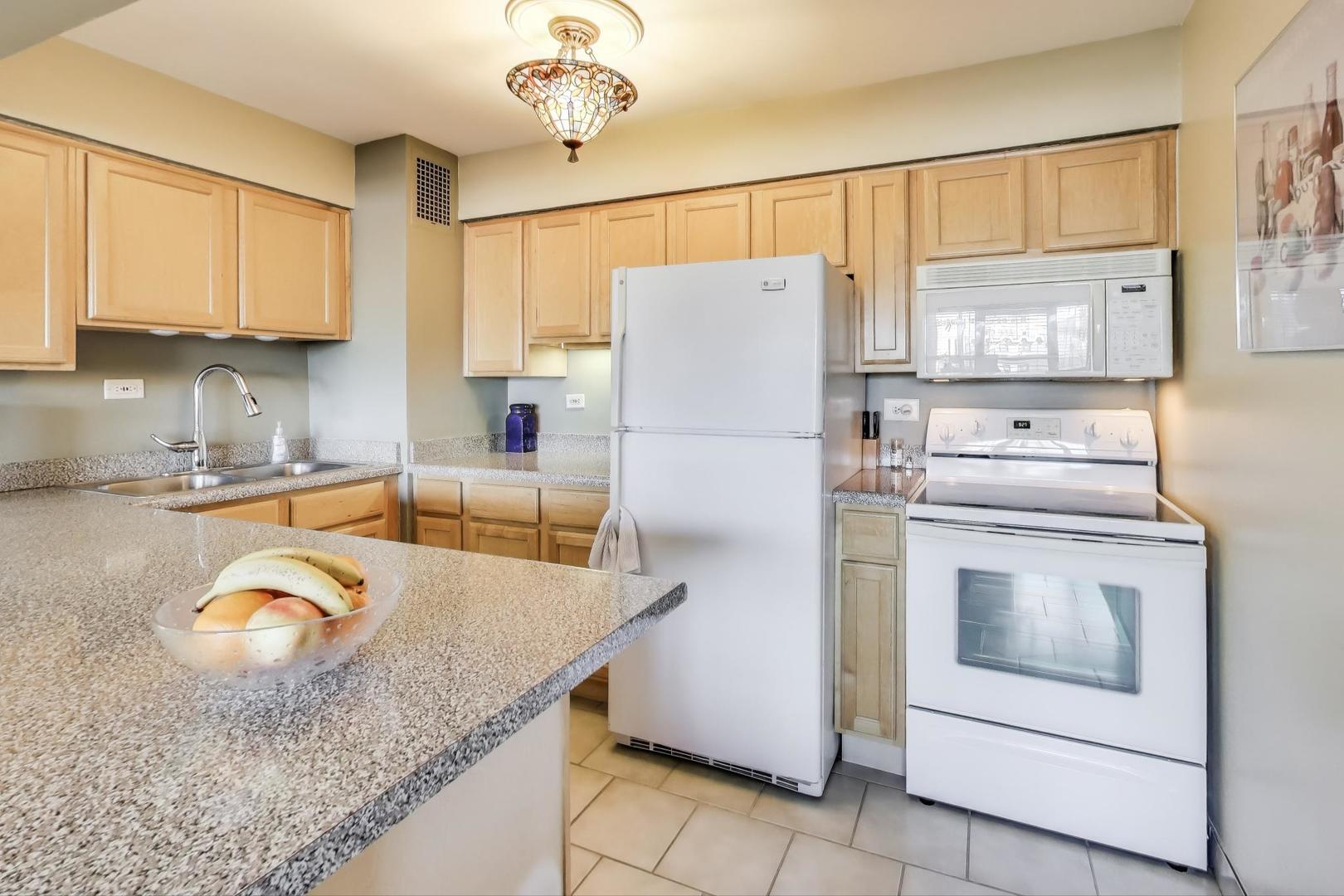 6030 North Sheridan Road, Unit 411 Chicago, IL 60660 - Photo 10 of 20 a kitchen with refrigerator cabinets and wooden floor