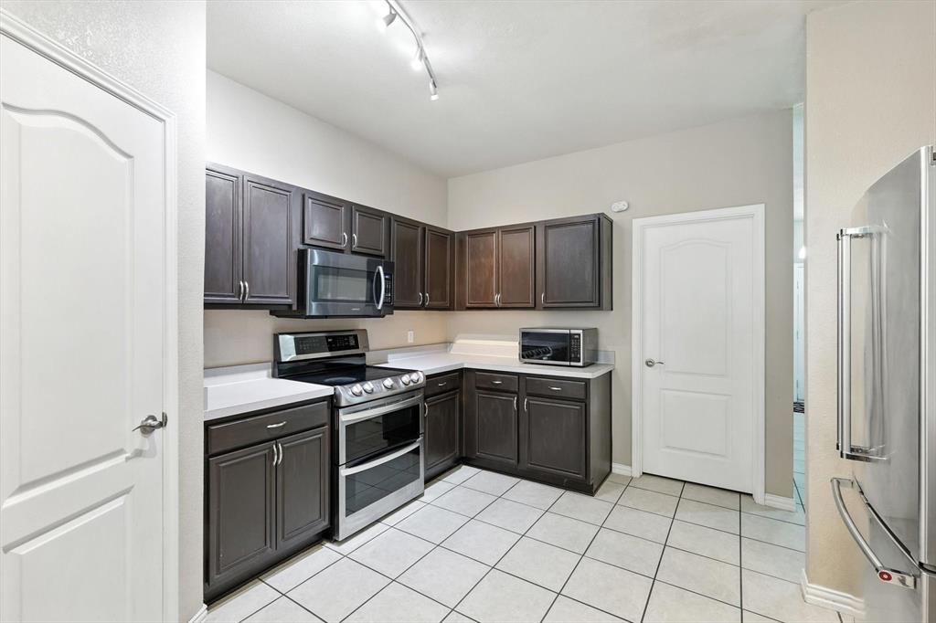 13521 Ponderosa Ranch Road Fort Worth, TX 76262 - Photo 11 of 27 a kitchen with stainless steel appliances granite countertop a stove top oven a sink and a refrigerator