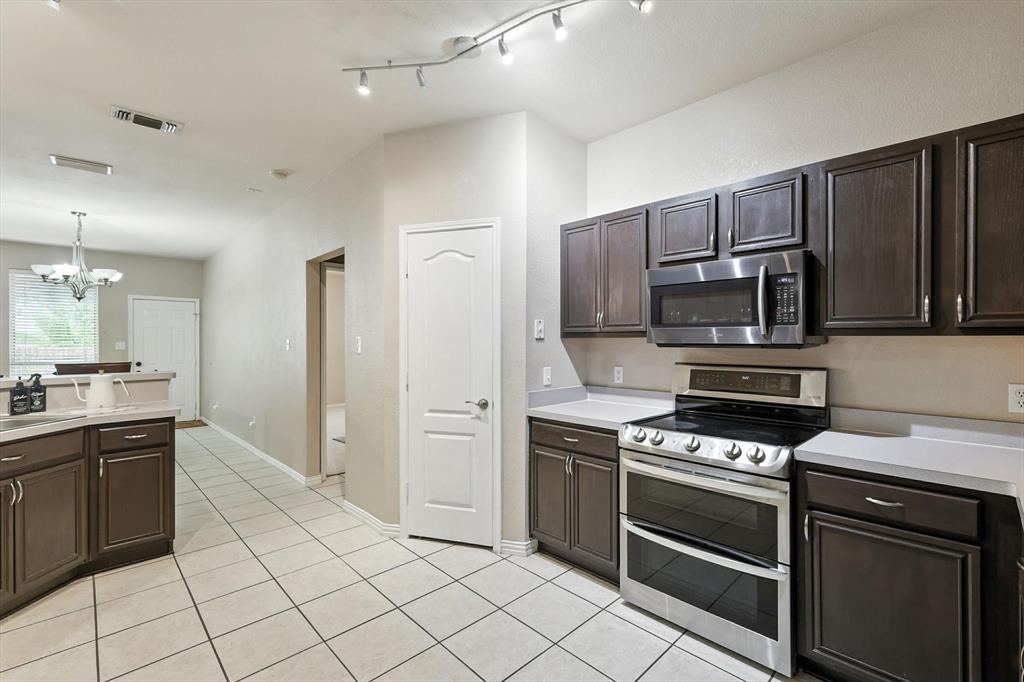 13521 Ponderosa Ranch Road Fort Worth, TX 76262 - Photo 13 of 27 a kitchen with kitchen island granite countertop a stove cabinets and refrigerator