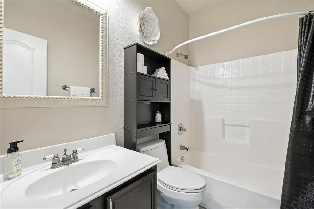 13521 Ponderosa Ranch Road Fort Worth, TX 76262 - Photo 20 of 27 a bathroom with a toilet a sink and a mirror