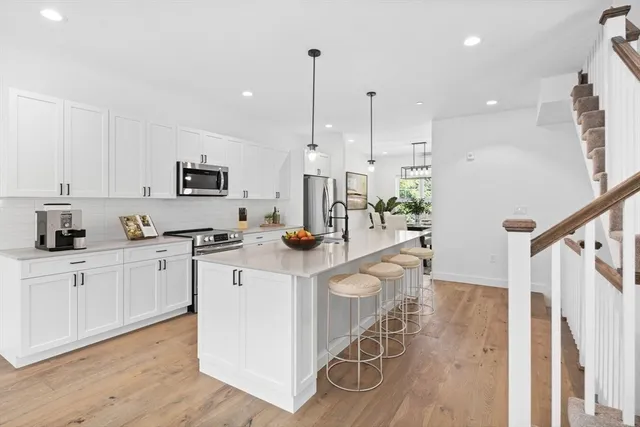 a kitchen with white cabinets and stainless steel appliances