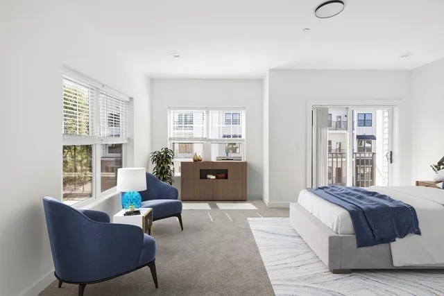 a spacious bedroom with a bed and wooden floor