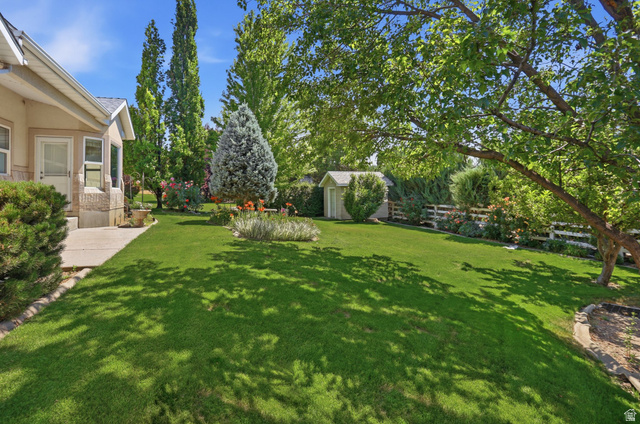 2190 750 West Perry, UT 84302 - Photo 4 of 42 Expansive backyard featuring a lush lawn, mature trees, and established landscaping