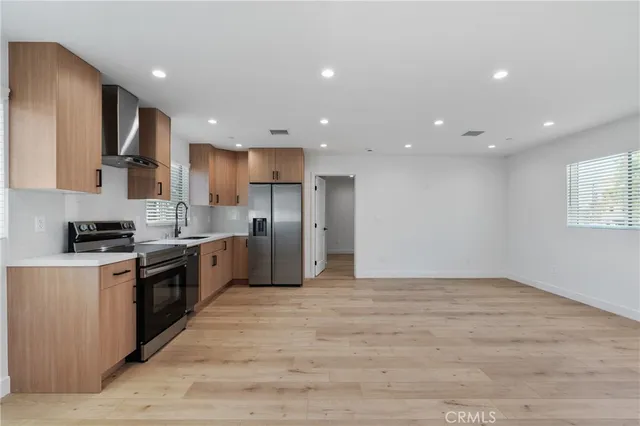 a large kitchen with stainless steel appliances granite countertop a stove a sink and a refrigerator