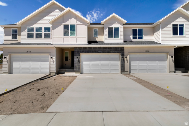 2840 West Aurora Avenue Mapleton, UT 84664 - Photo 1 of 14 Modern townhome exterior featuring light-toned siding, dark brick accents, and multiple dormer windows