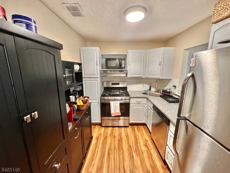 211 Sunshine Court Sayreville, NJ 08859 - Photo 5 of 15 a kitchen with a refrigerator a stove and a sink