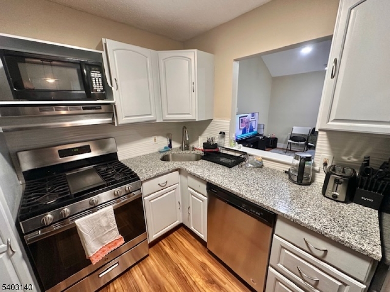 211 Sunshine Court Sayreville, NJ 08859 - Photo 6 of 15 a kitchen with sink a microwave and cabinets