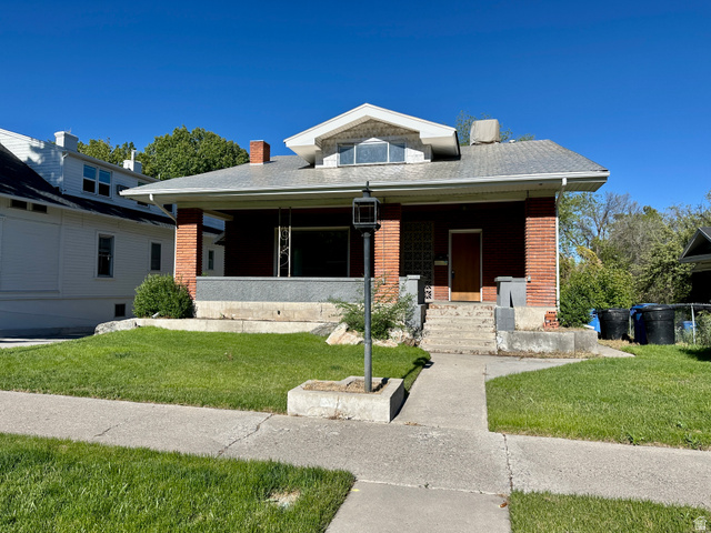 Brick facade residence with a covered front porch and a prominent gabled dormer