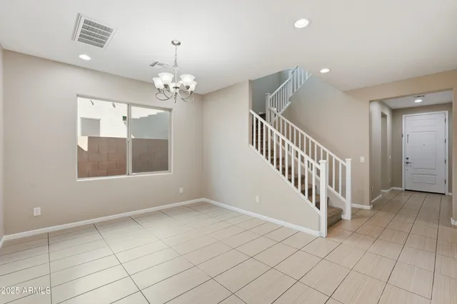 an empty room with windows and ceiling fan