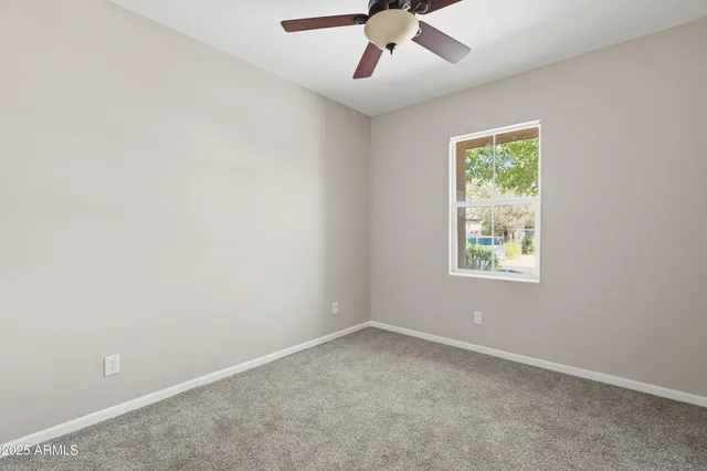 an empty room with a window and a fan