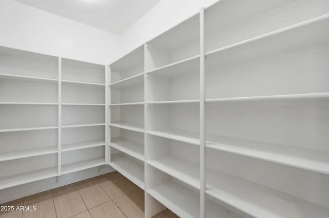 a view of walk in closet with empty racks