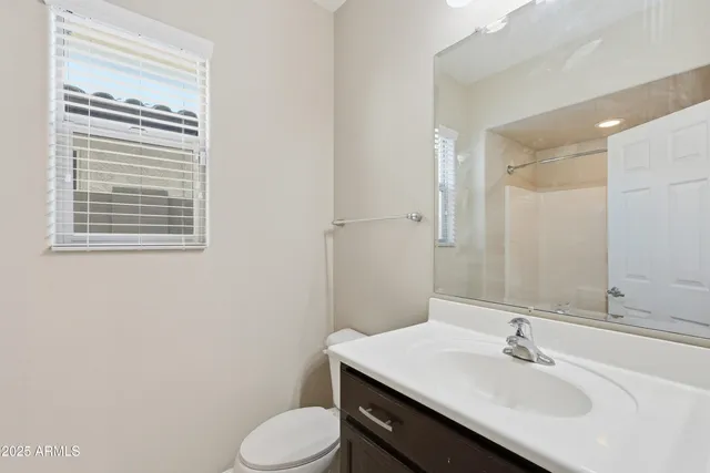 a bathroom with a sink toilet and mirror