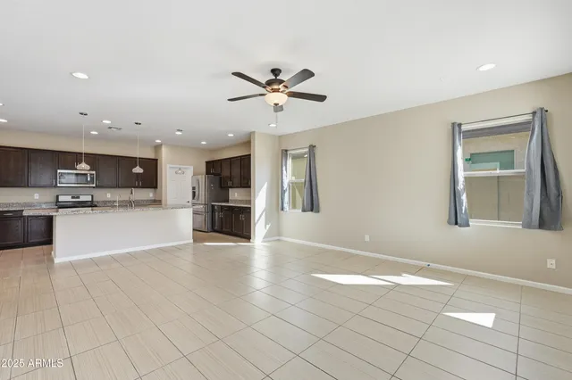 a view of a kitchen with kitchen island a sink stainless steel appliances and cabinets
