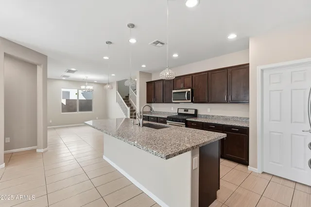 a kitchen with stainless steel appliances granite countertop a sink and a stove