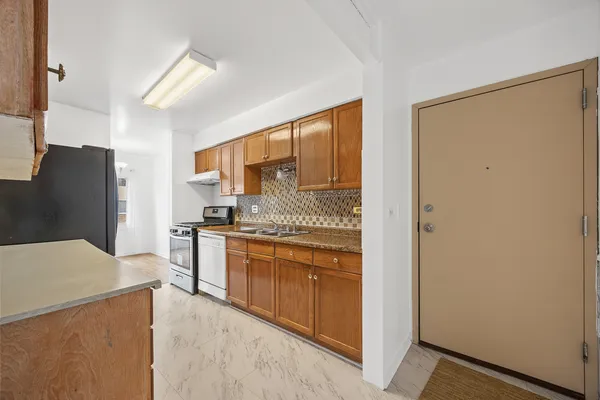 a kitchen with stainless steel appliances granite countertop a refrigerator and a stove