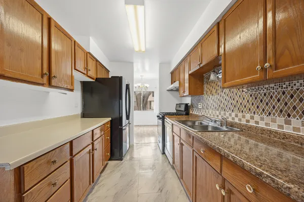 a kitchen with stainless steel appliances granite countertop a sink stove and refrigerator