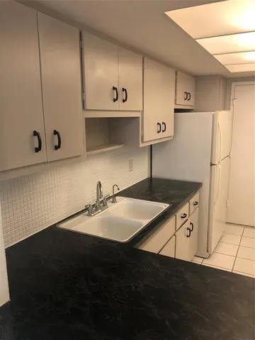 a kitchen with a sink a stove and cabinets