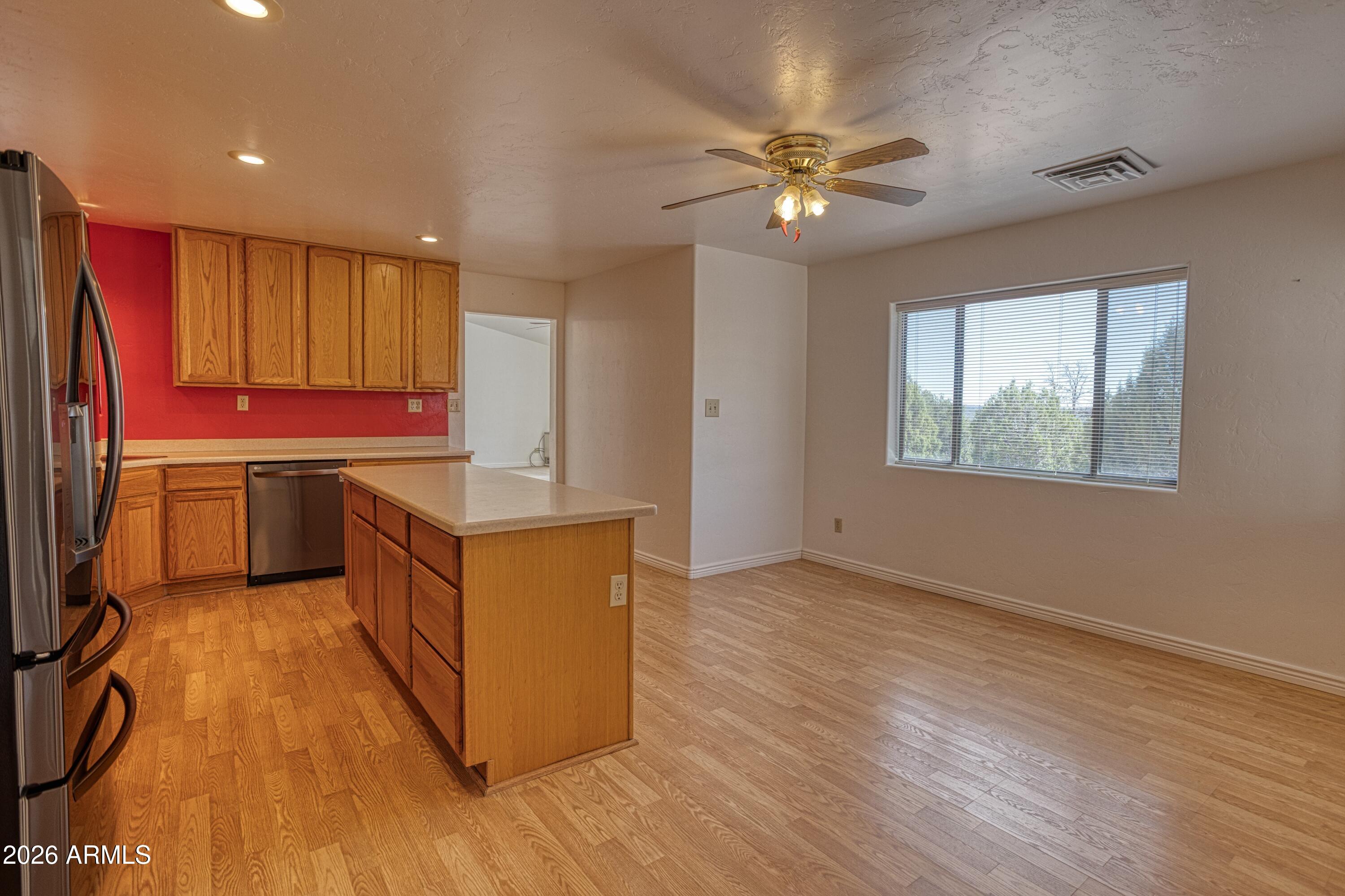 949 Geronimo Lane Show Low, AZ 85901 - Photo 11 of 43 a kitchen with stainless steel appliances granite countertop a sink a stove a refrigerator cabinets and wooden floor