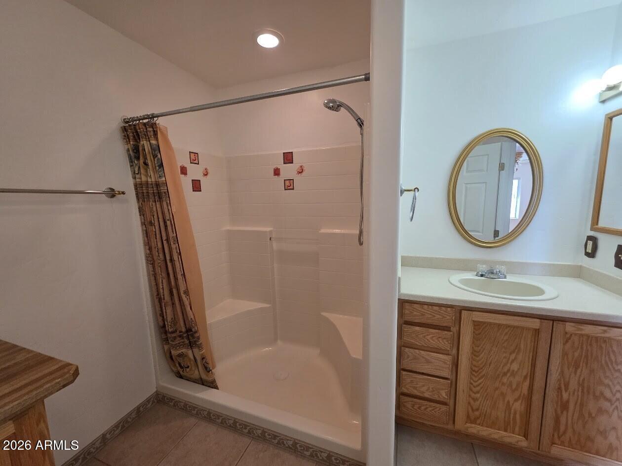 949 Geronimo Lane Show Low, AZ 85901 - Photo 24 of 43 a bathroom with a sink a mirror and a shower