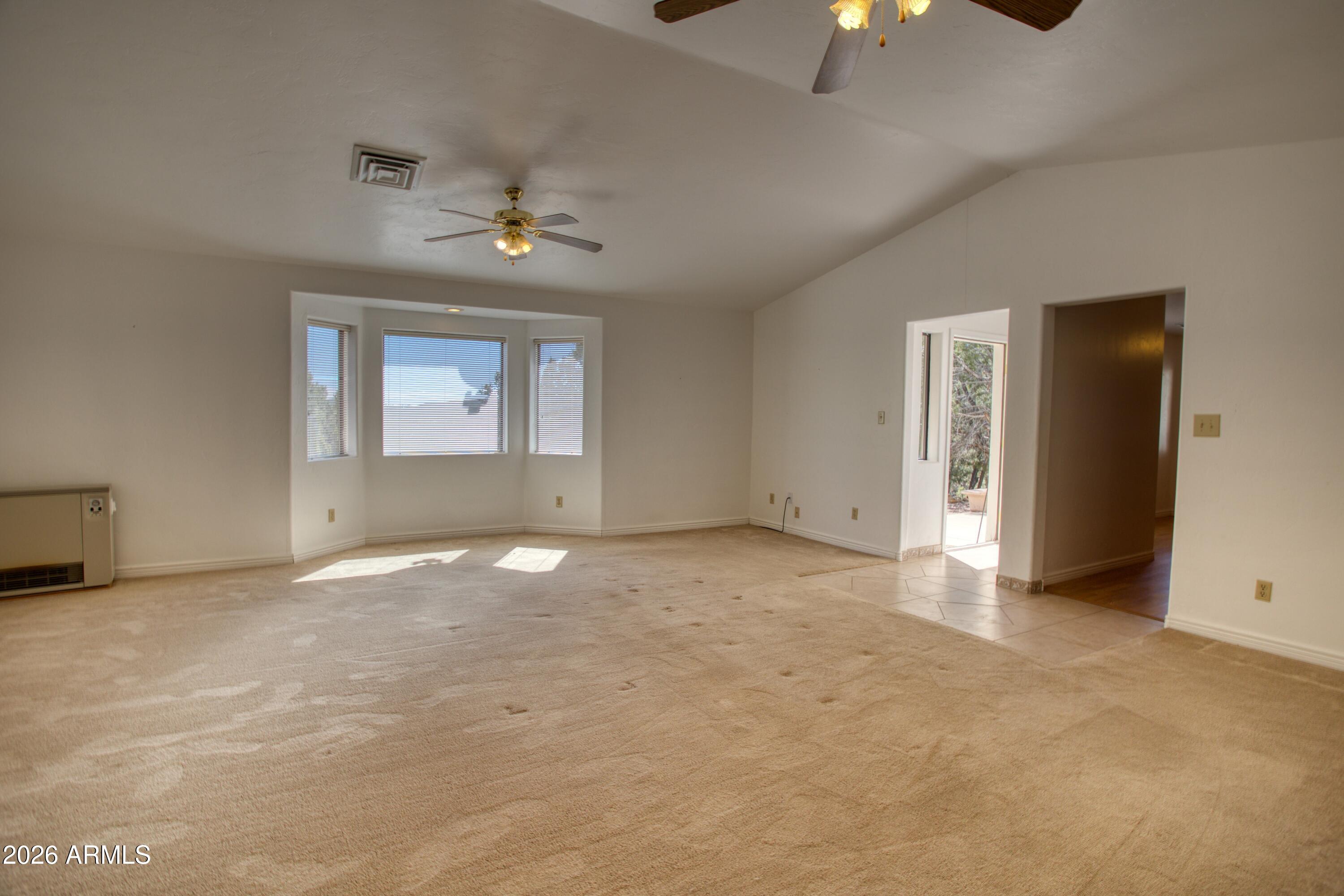 949 Geronimo Lane Show Low, AZ 85901 - Photo 8 of 43 an empty room with windows and fan