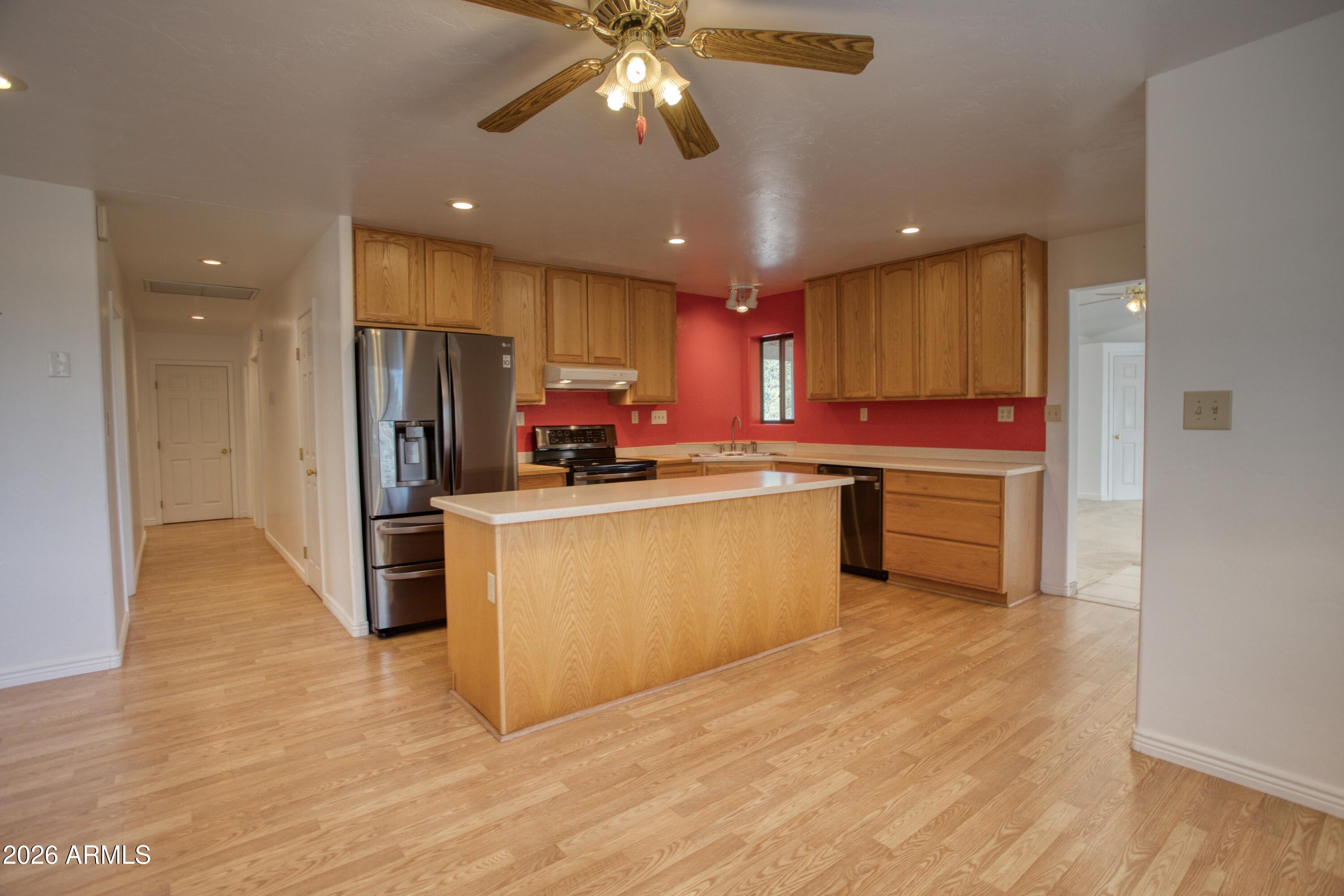 949 Geronimo Lane Show Low, AZ 85901 - Photo 9 of 43 a kitchen with stainless steel appliances a refrigerator sink and cabinets