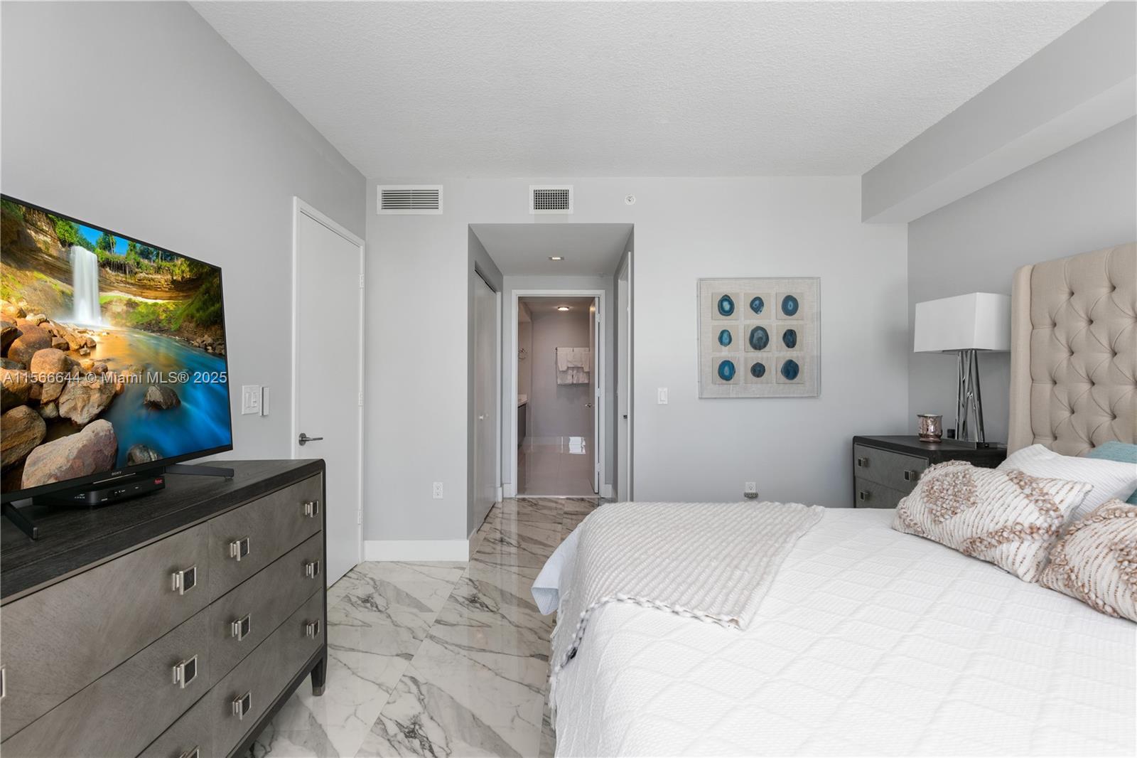 330 Sunny Isles Boulevard, Unit 51103 Sunny Isles Beach, FL 33160 - Photo 18 of 34 a bedroom with a bed and a flat screen tv