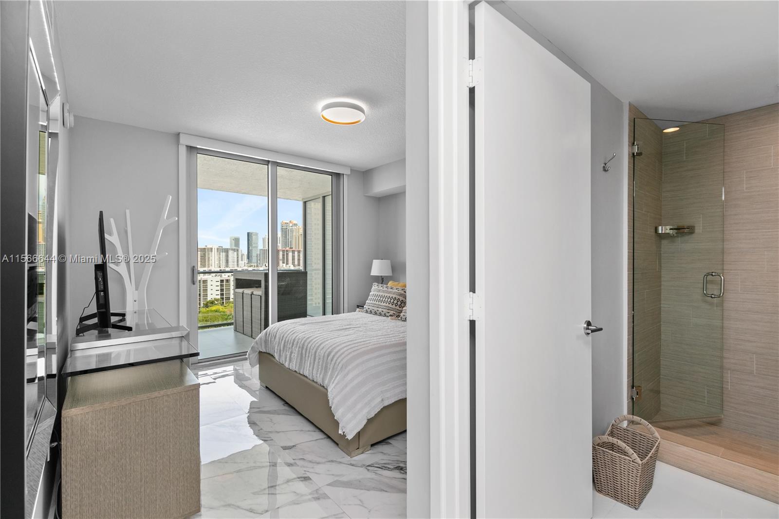 330 Sunny Isles Boulevard, Unit 51103 Sunny Isles Beach, FL 33160 - Photo 7 of 34 a large bedroom with a bed and glass door