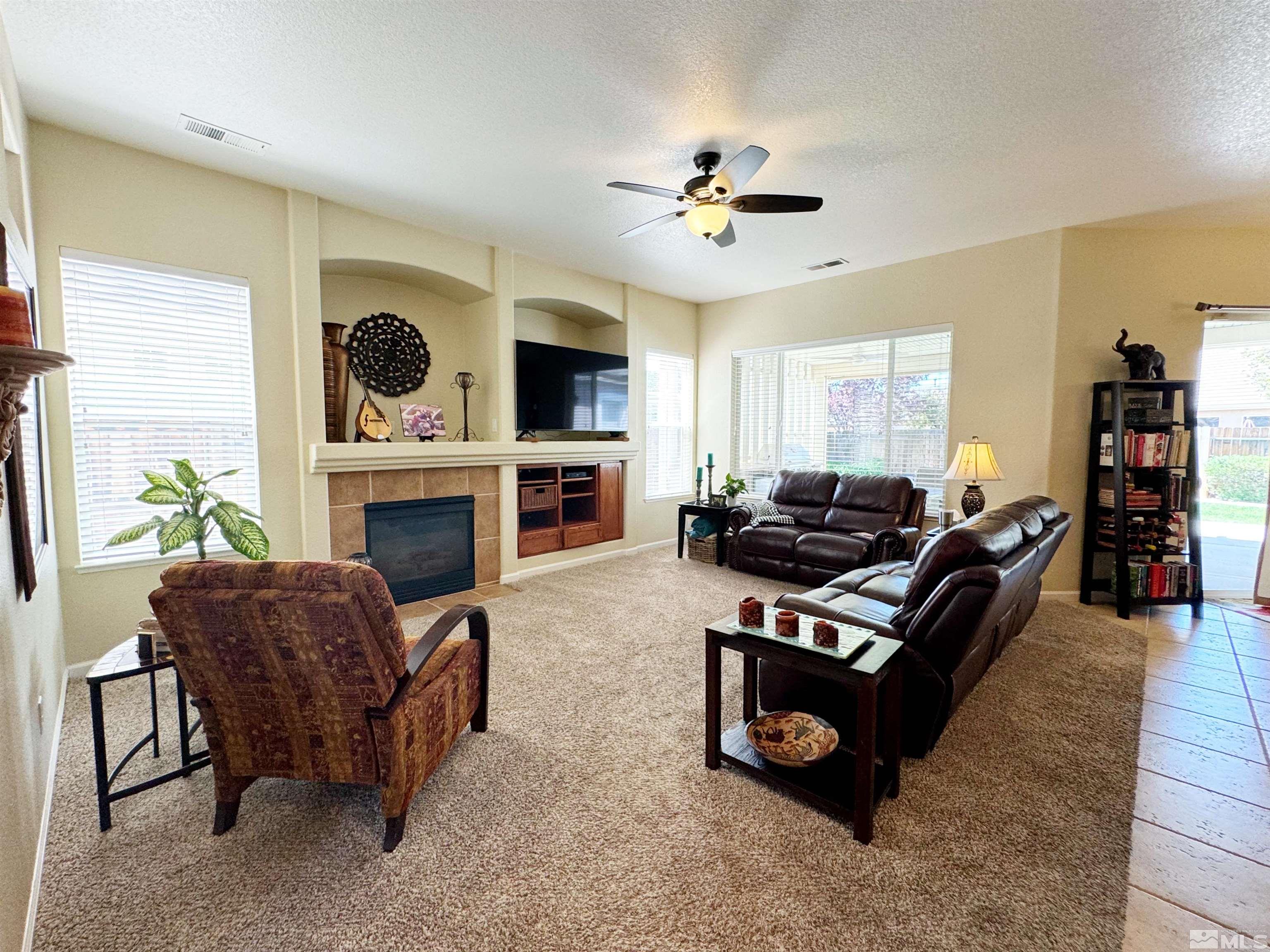9631 Glen Ridge Drive Reno, NV 89521 - Photo 8 of 34 a living room with furniture a fireplace and a flat screen tv