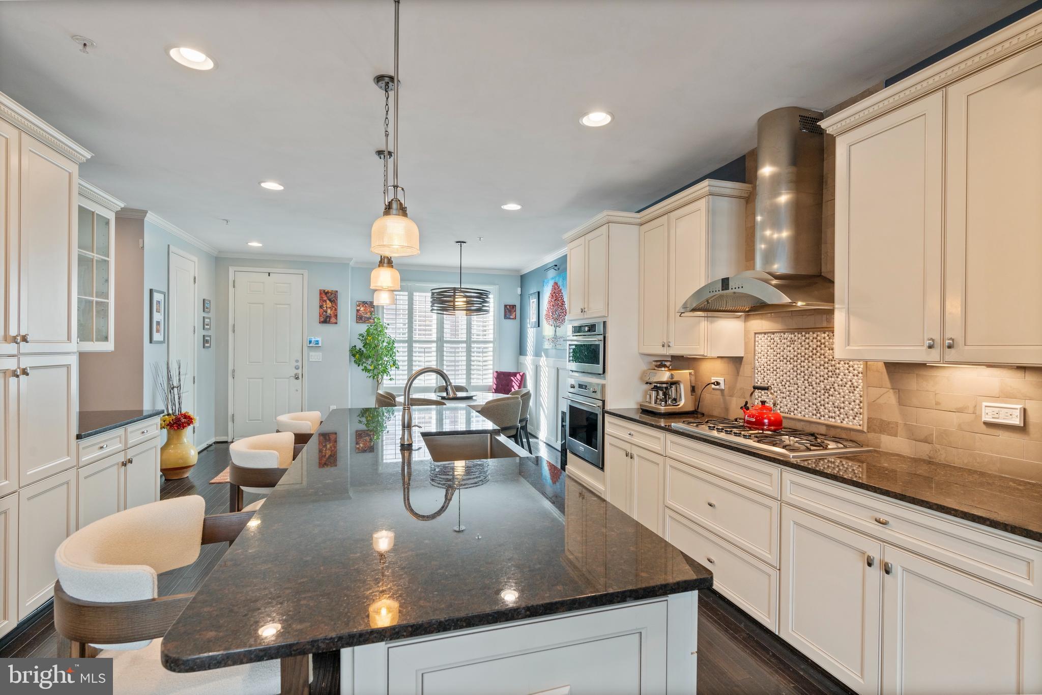 1311 Belt Street Baltimore, MD 21230 - Photo 8 of 65 a kitchen with stainless steel appliances granite countertop a sink a stove top oven a dining table and chairs with wooden floor