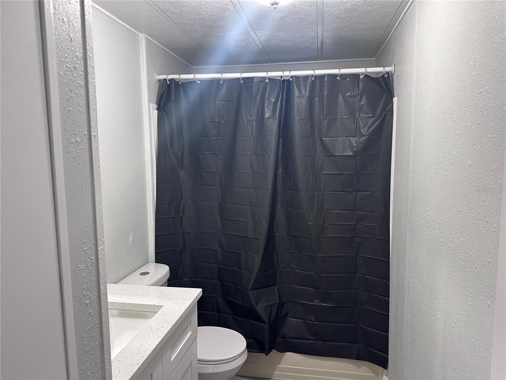3458 North Citrus Circle, Unit 1803 Zellwood, FL 32798 - Photo 11 of 20 a bathroom with a shower a toilet a sink and a shower