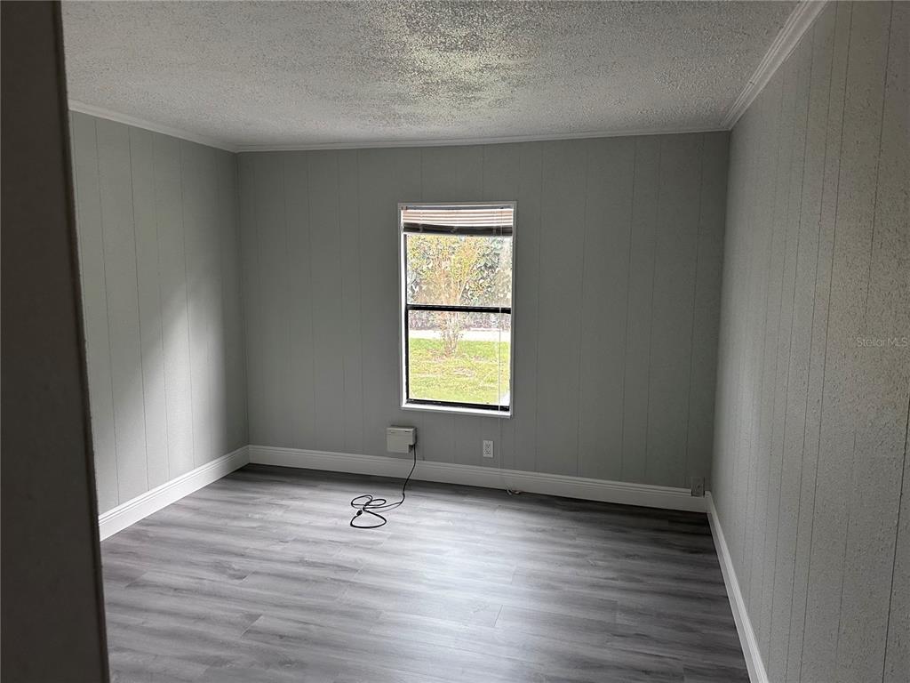 3458 North Citrus Circle, Unit 1803 Zellwood, FL 32798 - Photo 12 of 20 an empty room with wooden floor and windows