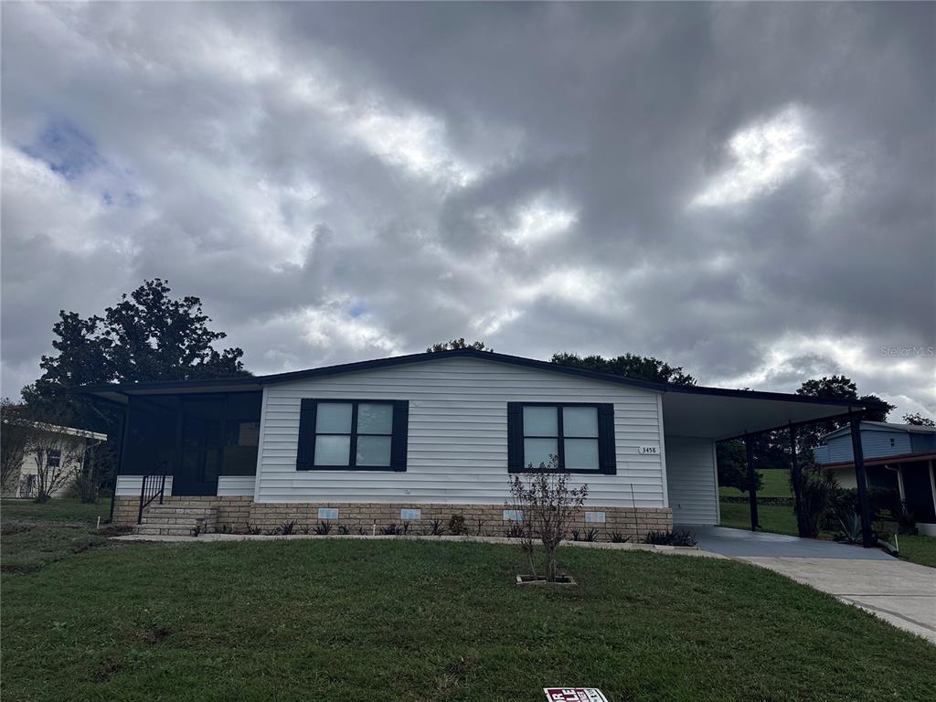 3458 North Citrus Circle, Unit 1803 Zellwood, FL 32798 - Photo 3 of 20 a front view of a house with a garden and yard