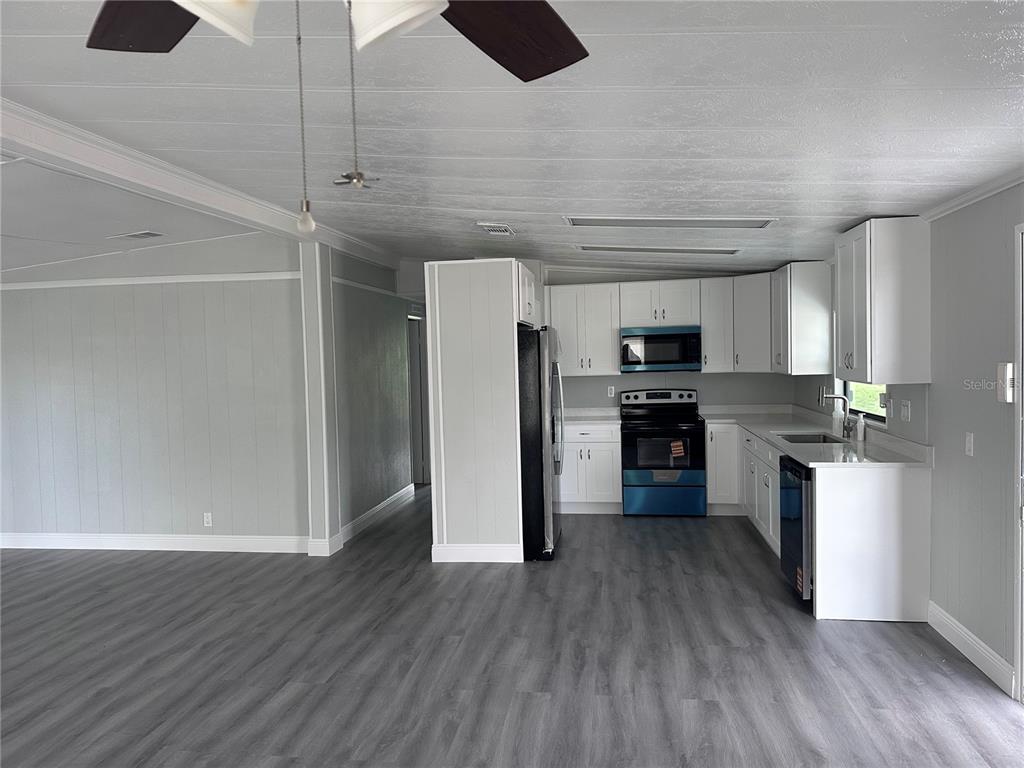 3458 North Citrus Circle, Unit 1803 Zellwood, FL 32798 - Photo 6 of 20 a kitchen with stainless steel appliances granite countertop a refrigerator and a stove top oven