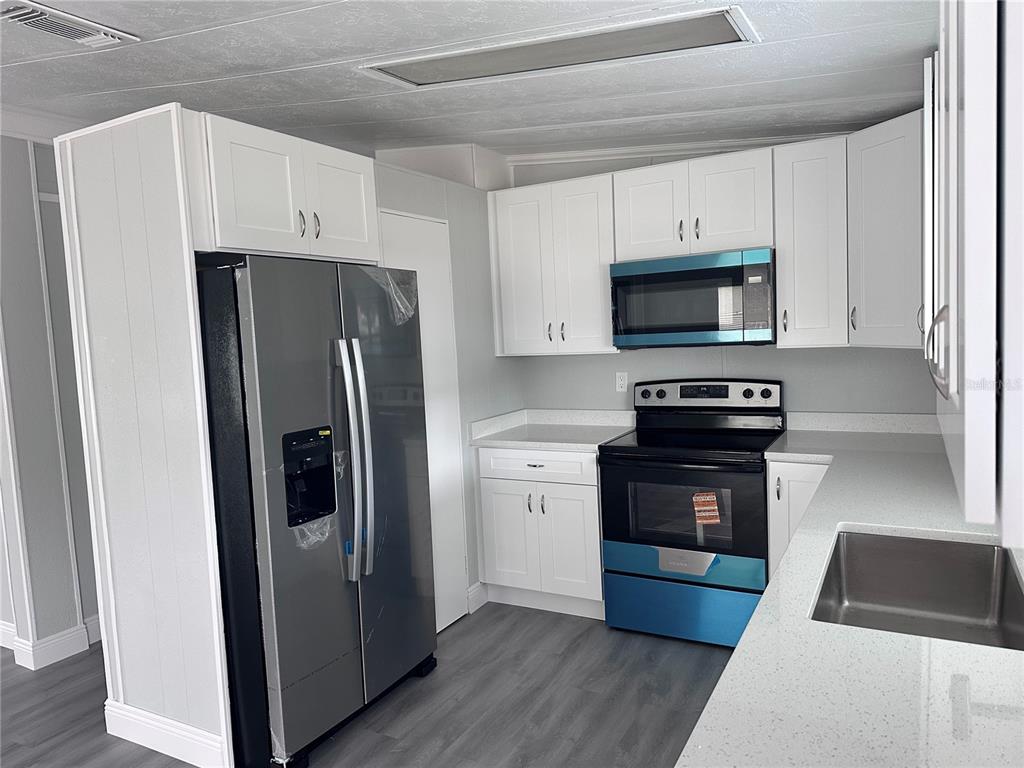 3458 North Citrus Circle, Unit 1803 Zellwood, FL 32798 - Photo 8 of 20 a kitchen with a refrigerator stove and microwave