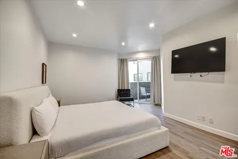 a bedroom with a bed tv and a window