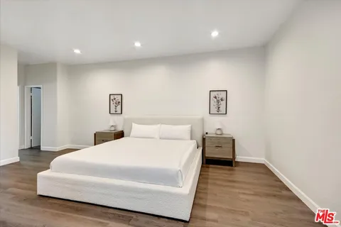 a bedroom with a bed and wooden floor