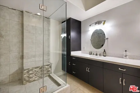 a bathroom with a double vanity sink mirror and shower