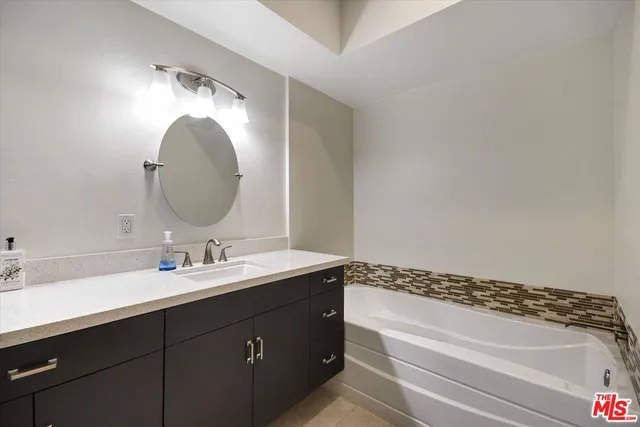 a bathroom with a granite countertop sink and a mirror