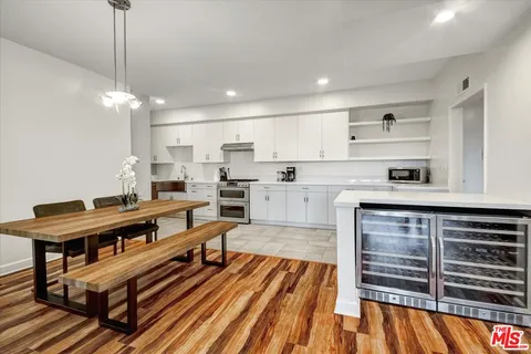 a open kitchen with stainless steel appliances granite countertop a stove and a wooden floors