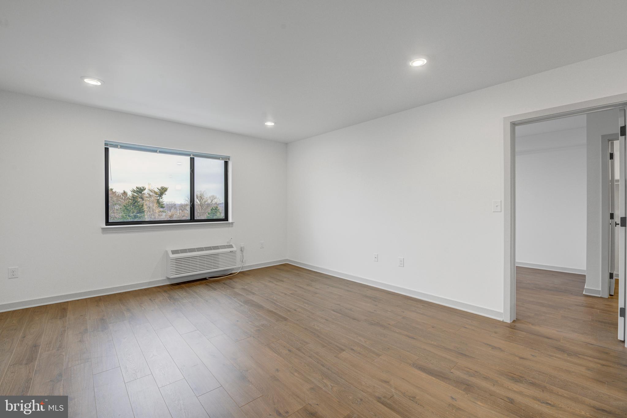 6808 Ridge Avenue, Unit 418 Philadelphia, PA 19128 - Photo 5 of 10 a view of an empty room with wooden floor and a window