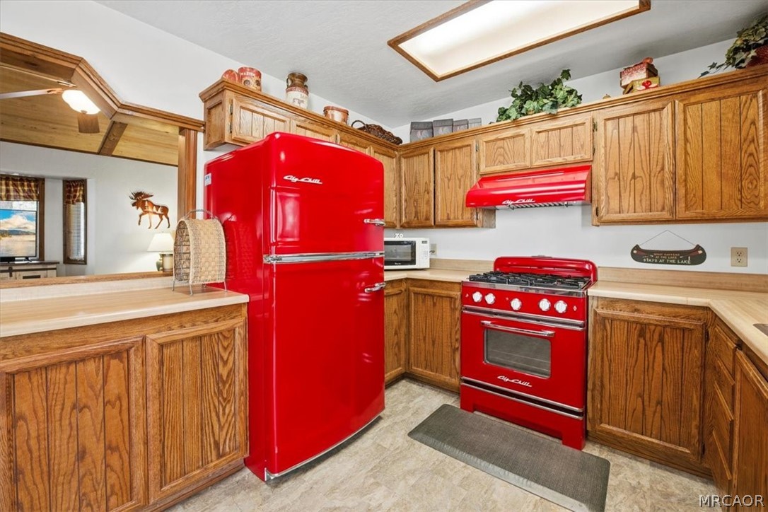 358 Victoria Lane Sugarloaf, CA 92386 - Photo 16 of 38 a utility room with stainless steel appliances granite countertop a stove a refrigerator and a microwave